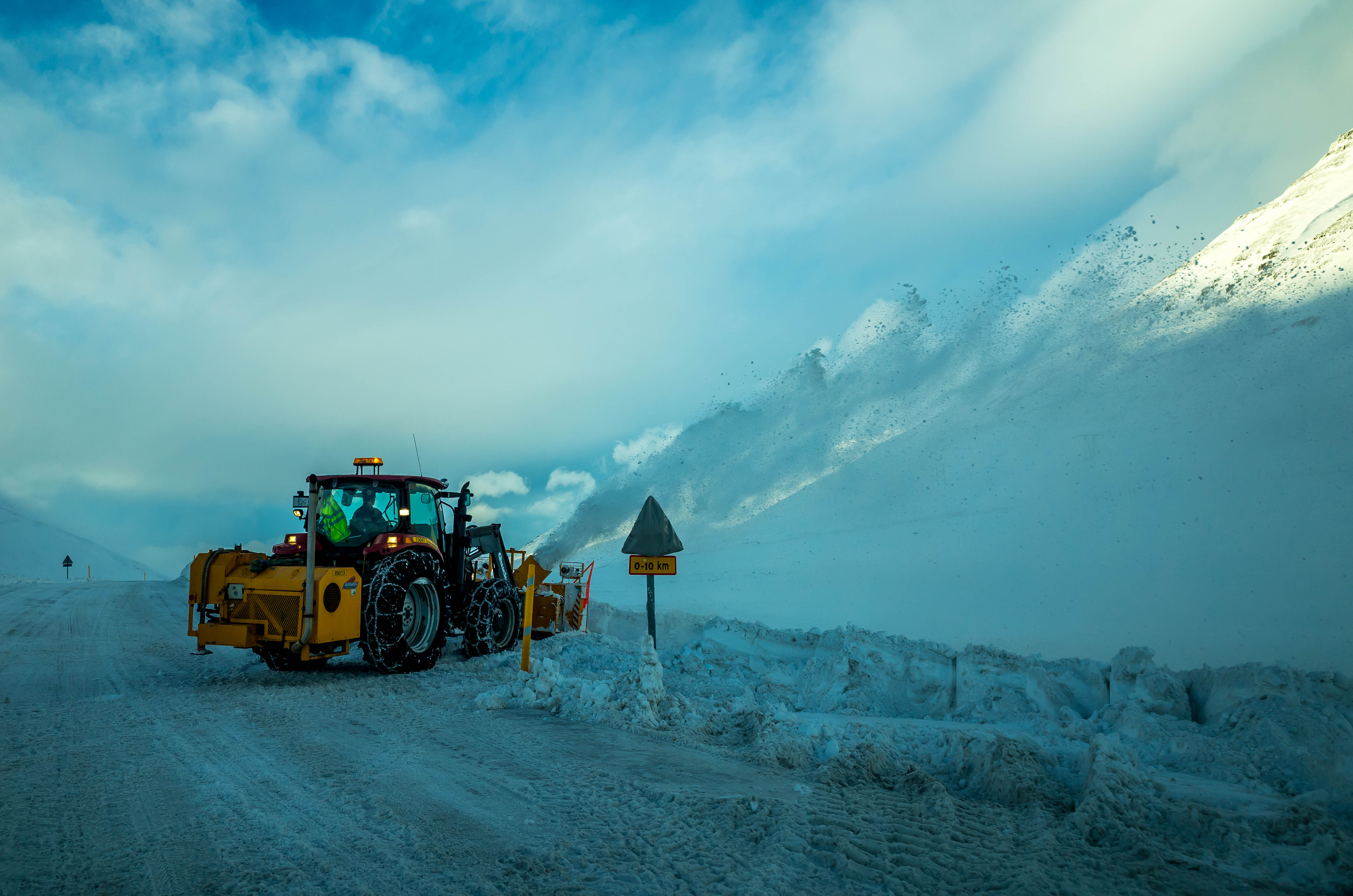 冰島一號公路冬季由雪地清雪車處理路面,旁有警示牌;