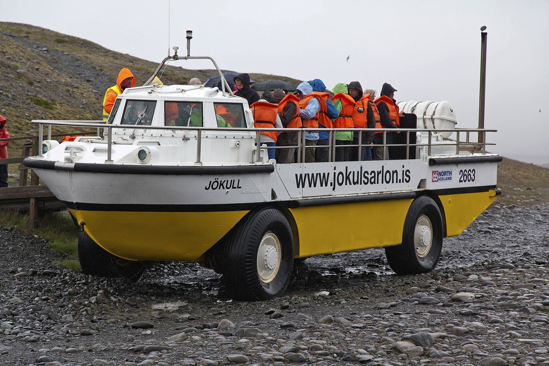 Jökulsárlón 岸邊黃色兩棲船停靠,旅客在石灘附近準備登船;