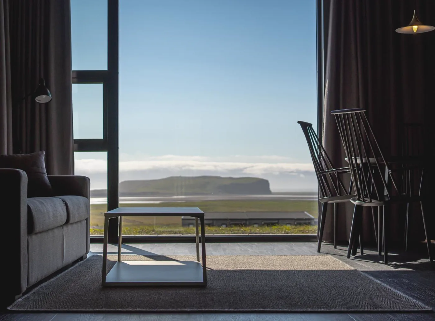 Black Beach Suites 官方開放式套房實景,見到用餐位、小廚房、沙發與大窗。