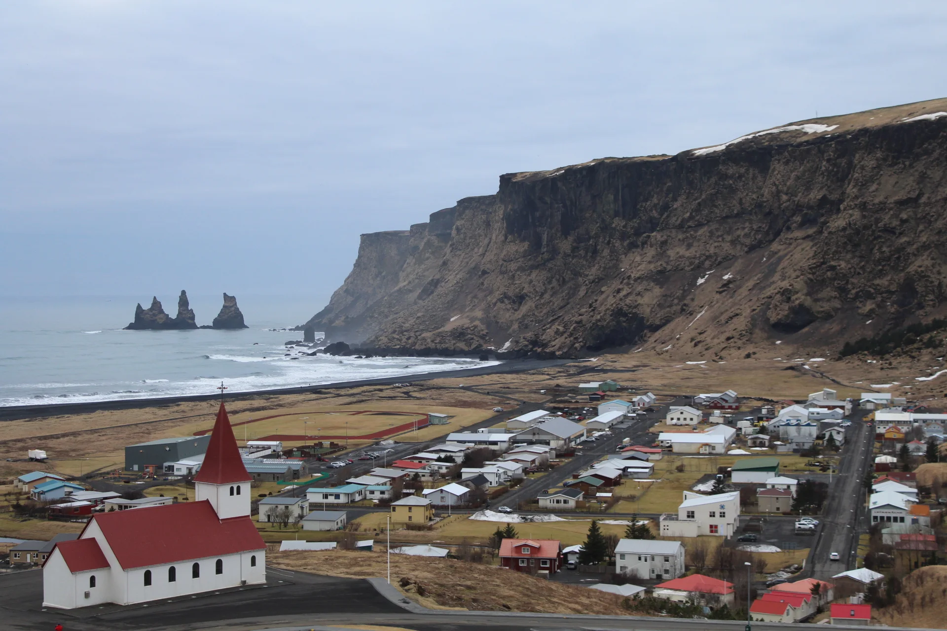 維克(Vík)小鎮、教堂、黑沙海岸與山崖的真實景觀。